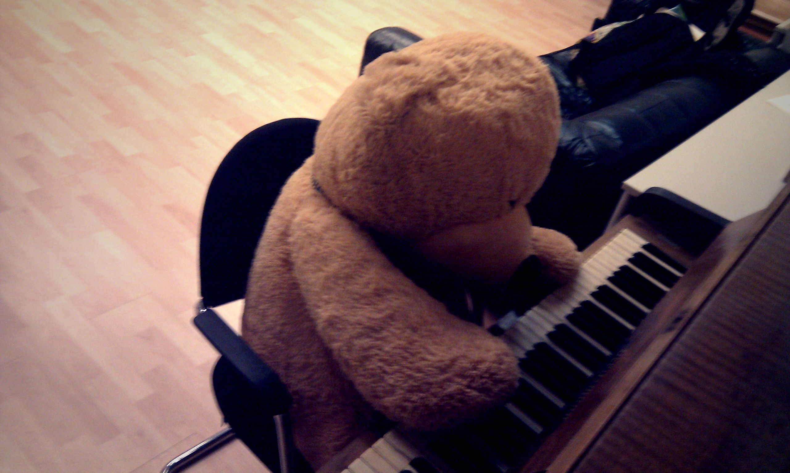 A huge teddybear playing piano